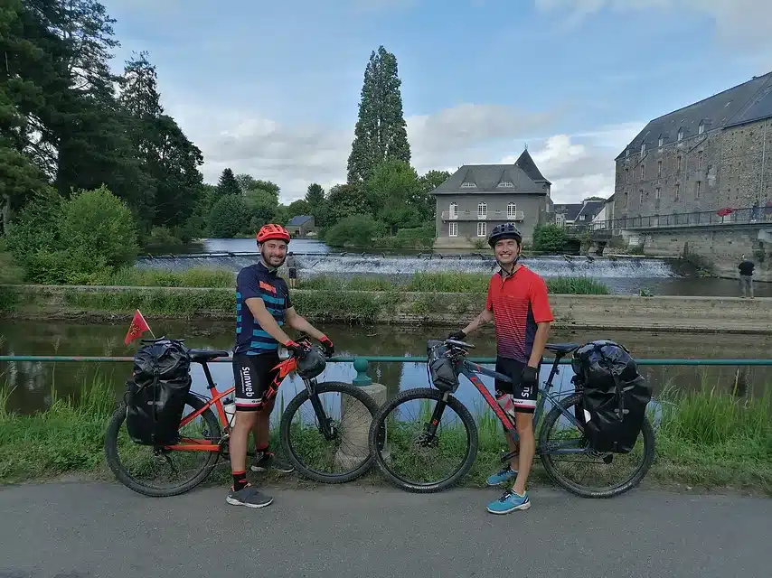 Photo de 2 hommes sur leur vélo à l'arrêt proche d'un canal.